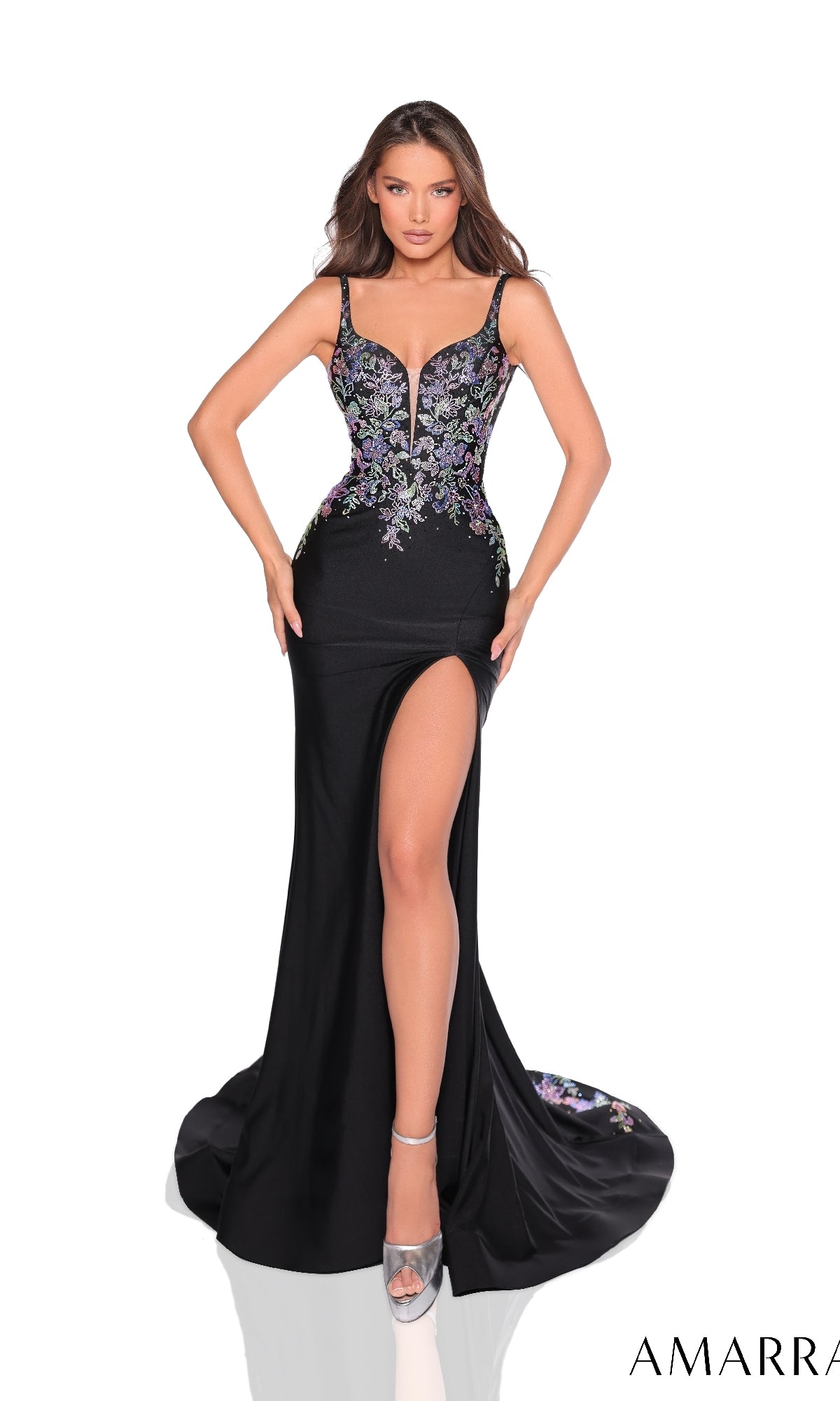 Model wearing the Amarra 88242 Long Prom Dress?black, fitted, with floral embroidery, deep neckline, high thigh slit, and lace-up back?standing hands on hips against a plain white background.
